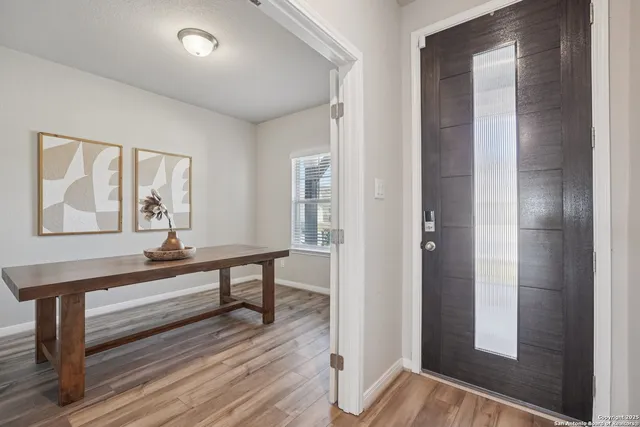 a view of a hallway with wooden floor and stairs