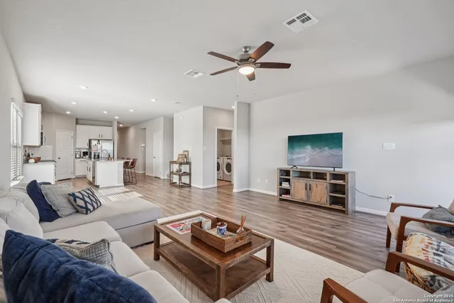 a living room with furniture a flat screen tv and kitchen view