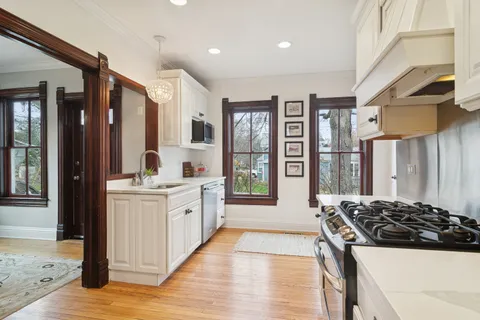 a large kitchen with stainless steel appliances granite countertop a stove and a refrigerator