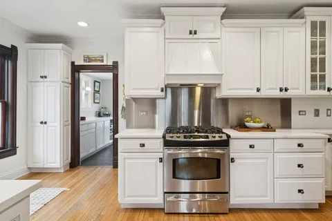 a kitchen with stainless steel appliances white cabinets and a stove a refrigerator
