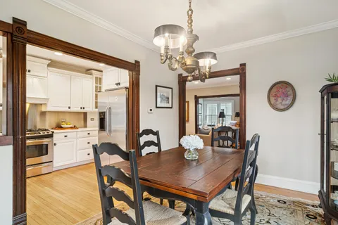 a view of a dining room with furniture a chandelier and wooden floor