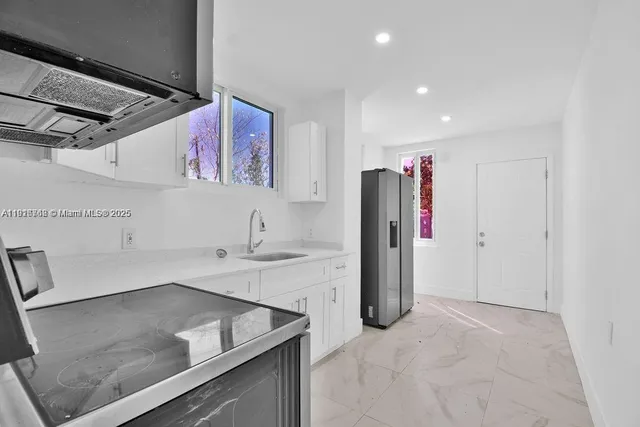 a view of a kitchen with a sink and refrigerator