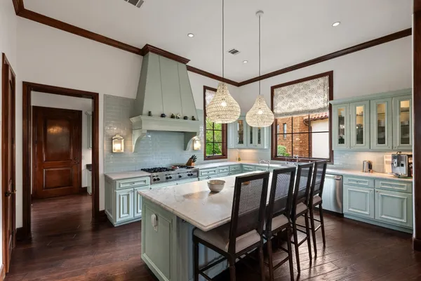 a kitchen with stainless steel appliances granite countertop a stove a sink dishwasher and a refrigerator with wooden floor