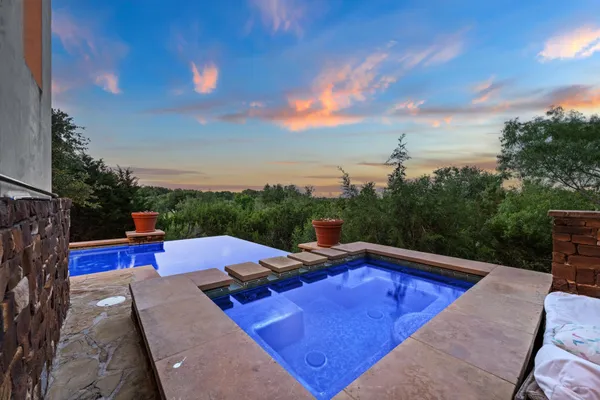 a view of a swimming pool with a patio and a yard