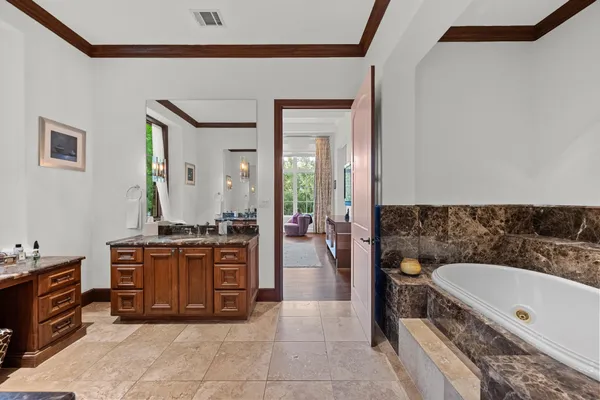 a spacious bathroom with a granite countertop tub double vanity sink and a mirror