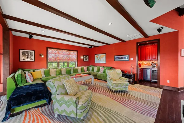 a living room with furniture a rug and a floor to ceiling window