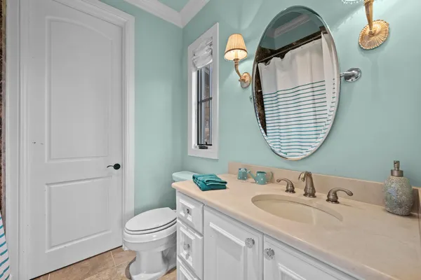 a bathroom with a granite countertop toilet sink and mirror