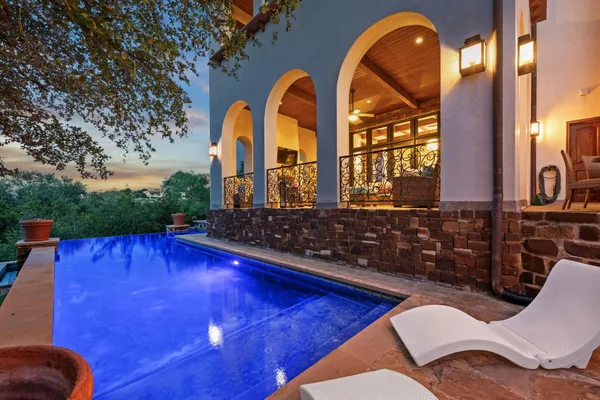 a view of swimming pool with outdoor seating and plants