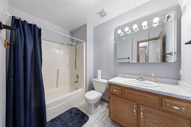 a bathroom with a sink a toilet a large mirror a bathtub and shower