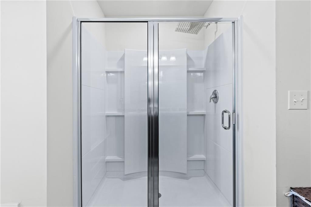 5367 Pennington Court Atlanta, GA 30349 - Photo 20 of 33 a bathroom with a glass shower door