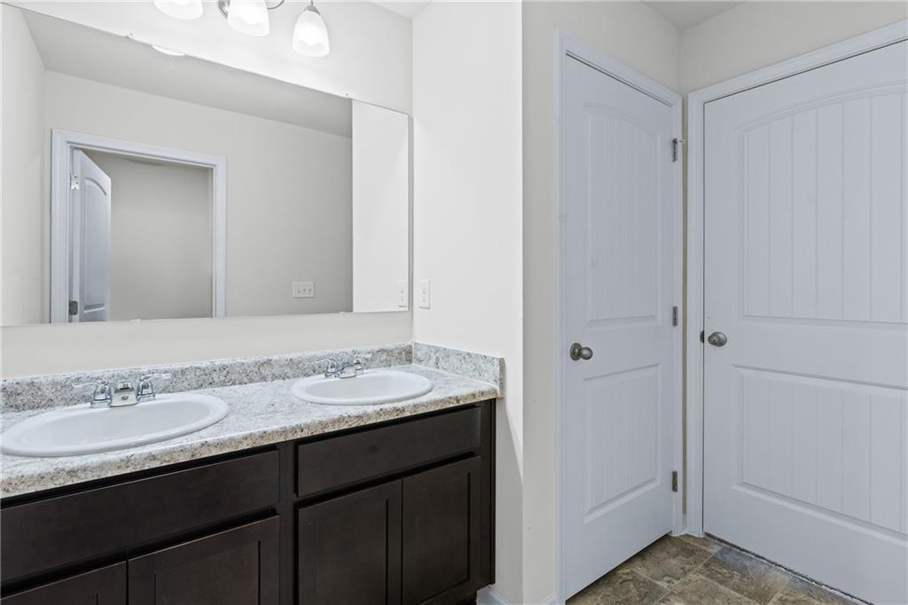 5367 Pennington Court Atlanta, GA 30349 - Photo 23 of 33 a bathroom with a granite countertop sink and a mirror