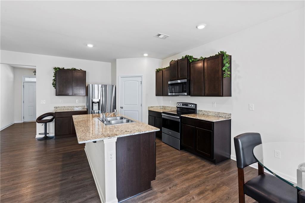 5367 Pennington Court Atlanta, GA 30349 - Photo 8 of 33 a kitchen with stainless steel appliances a stove a sink a microwave a refrigerator and furniture