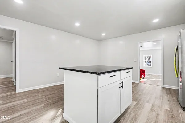 a kitchen with granite countertop white cabinets and white appliances