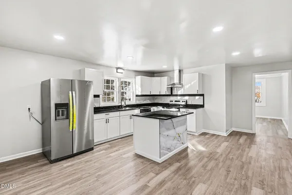 a kitchen with stainless steel appliances granite countertop a refrigerator and a stove top oven
