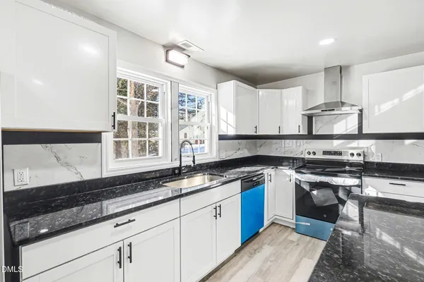 a kitchen with stainless steel appliances granite countertop a sink stove and cabinets