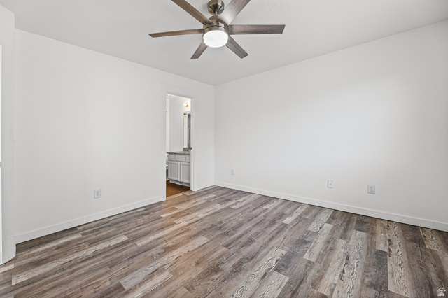 5525 Hampton Way Stansbury Park, UT 84074 - Photo 17 of 35 Spacious room featuring wood-finish flooring, white walls, and a ceiling fan with integrated lighting