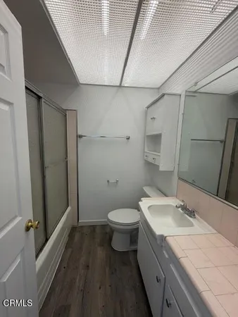a bathroom with a granite countertop sink toilet and shower