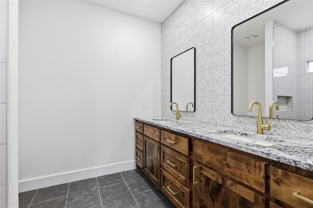 1413 Ridgeview Circle Granbury, TX 76048 - Photo 21 of 35 Double vanity featuring wood-finish cabinetry, granite countertops, and two rectangular undermount sinks with gold-tone hardware
