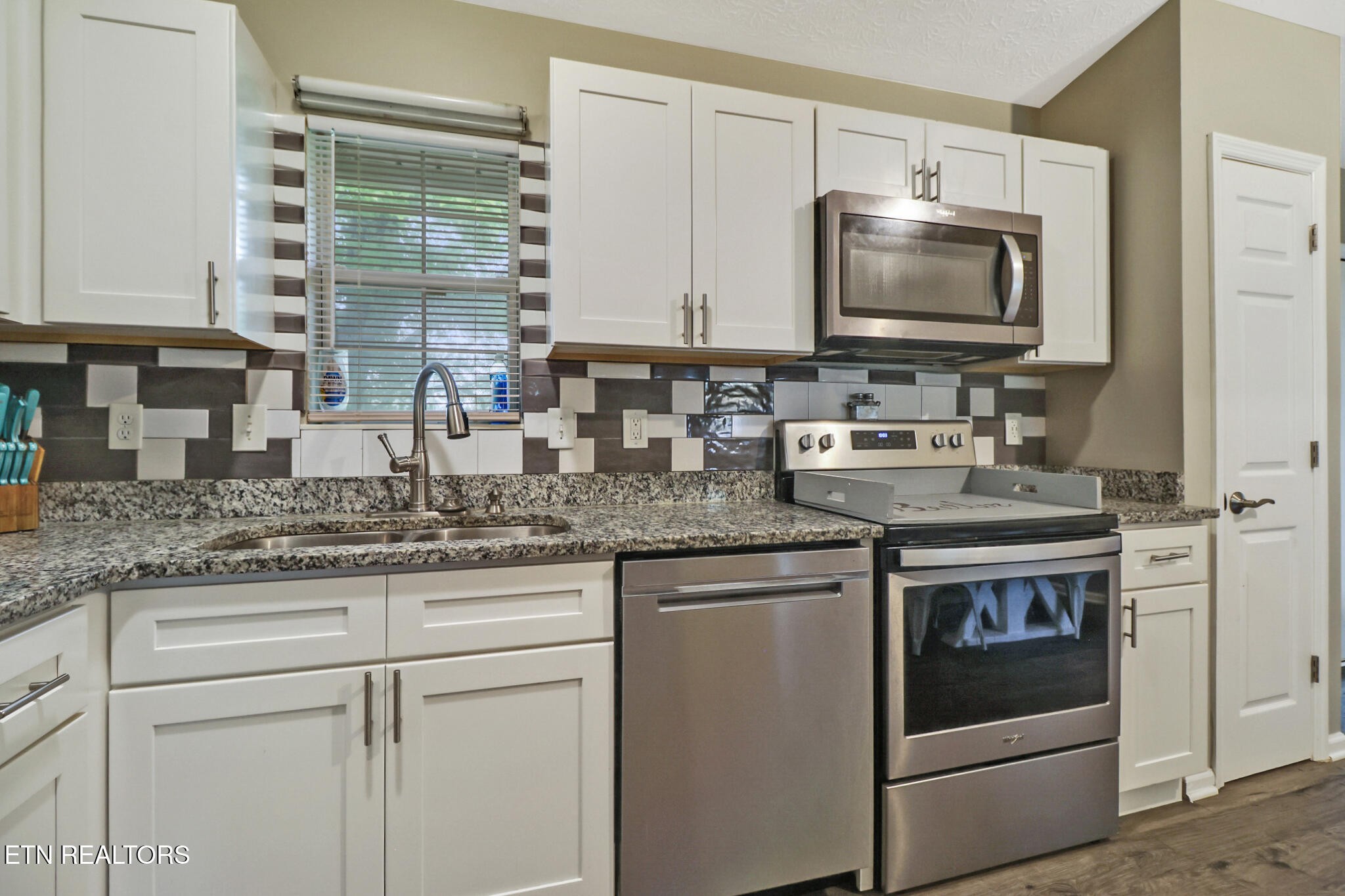 604 Bear Cub Lane Clinton, TN 37716 - Photo 8 of 23 a kitchen with granite countertop a sink stainless steel appliances and cabinets