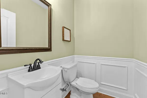 a kitchen with stainless steel appliances granite countertop wooden floors a stove a sink a dining table and chairs