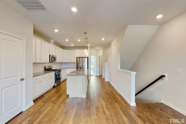 a kitchen with granite countertop a sink a stove and cabinets