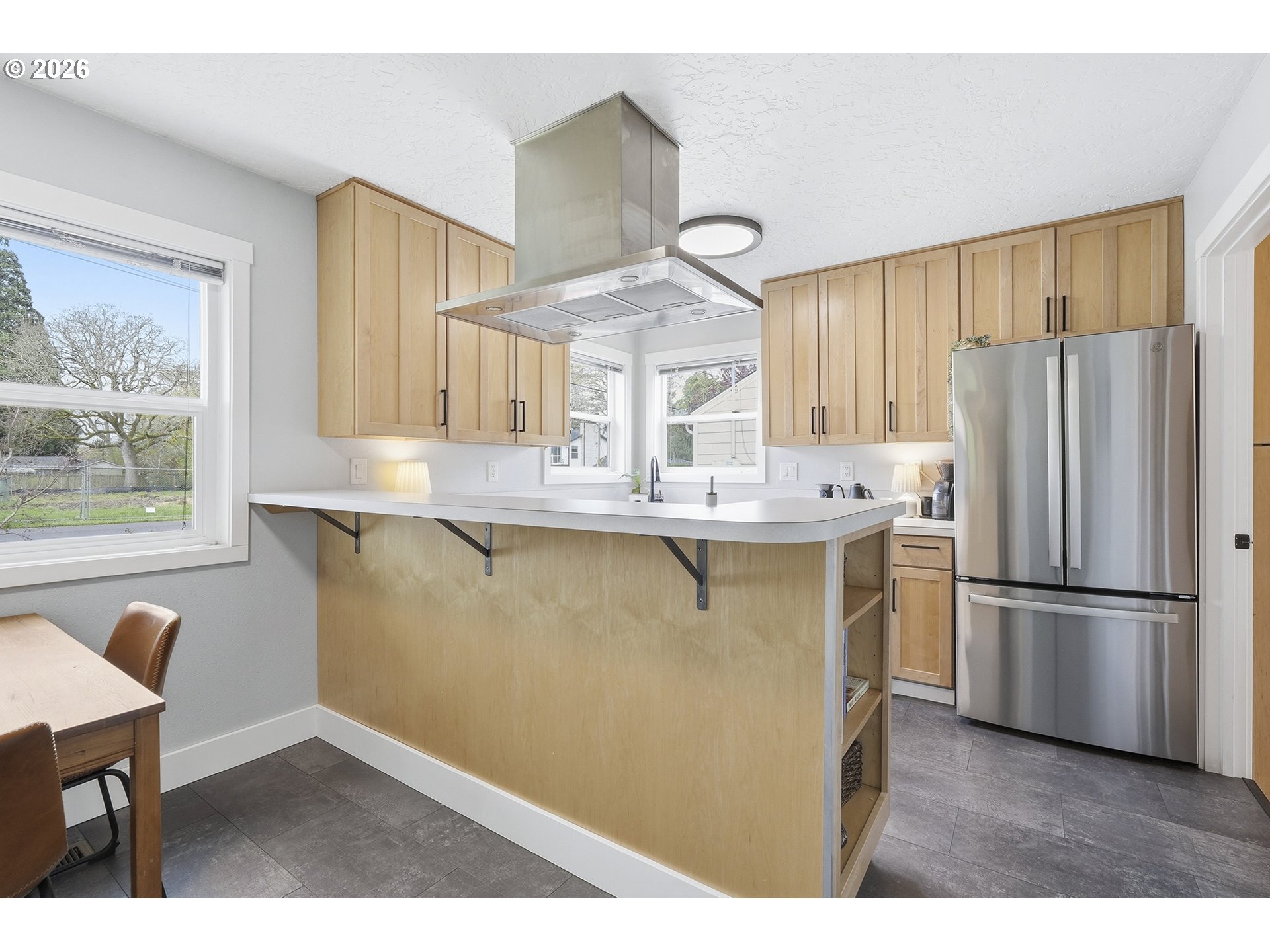 11250 Southwest 78th Avenue Tigard, OR 97223 - Photo 12 of 30 a kitchen with kitchen island a refrigerator cabinets and wooden floor