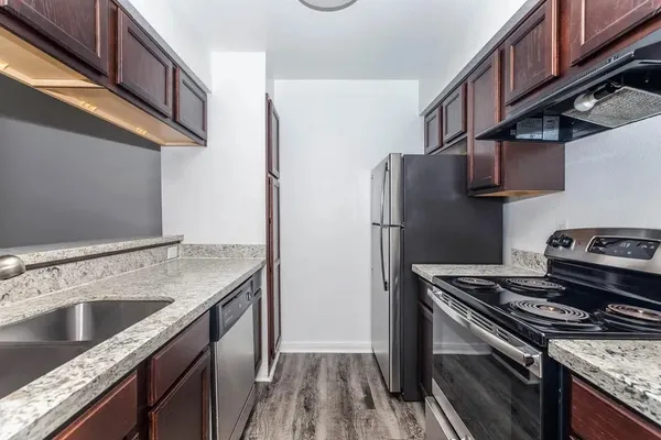 a kitchen with stainless steel appliances granite countertop a refrigerator and a stove