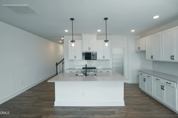 a view of a kitchen with kitchen island a sink stainless steel appliances and cabinets