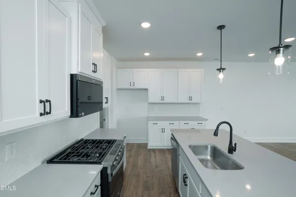 a kitchen with stainless steel appliances granite countertop a sink a stove and a refrigerator