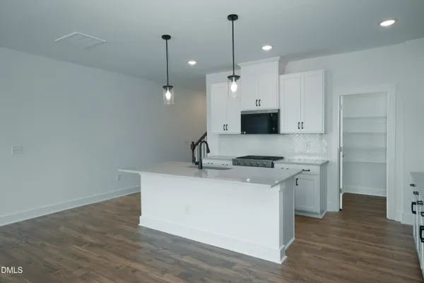 a kitchen with a sink a stove and a wooden floor