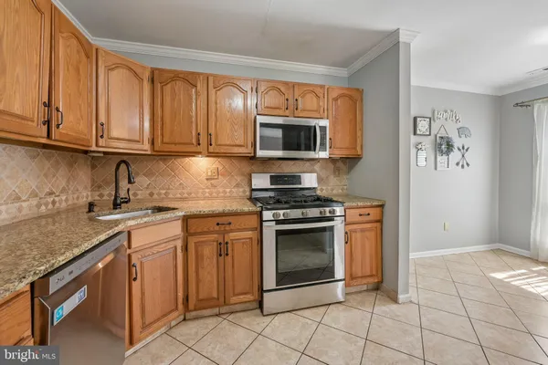 a kitchen with granite countertop a stove top oven microwave and cabinets