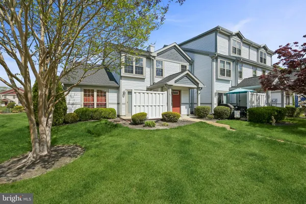 a front view of a house with yard and green space