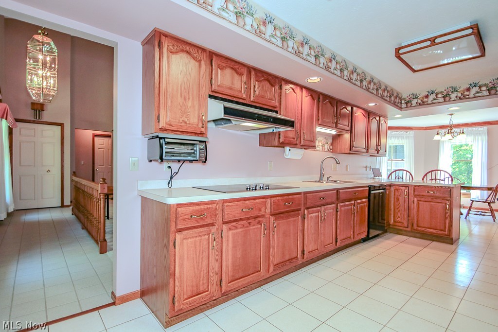 6475 Taylor Road Painesville, OH 44077 - Photo 6 of 23 Kitchen featuring wood cabinetry, solid surface countertops, and white tile flooring