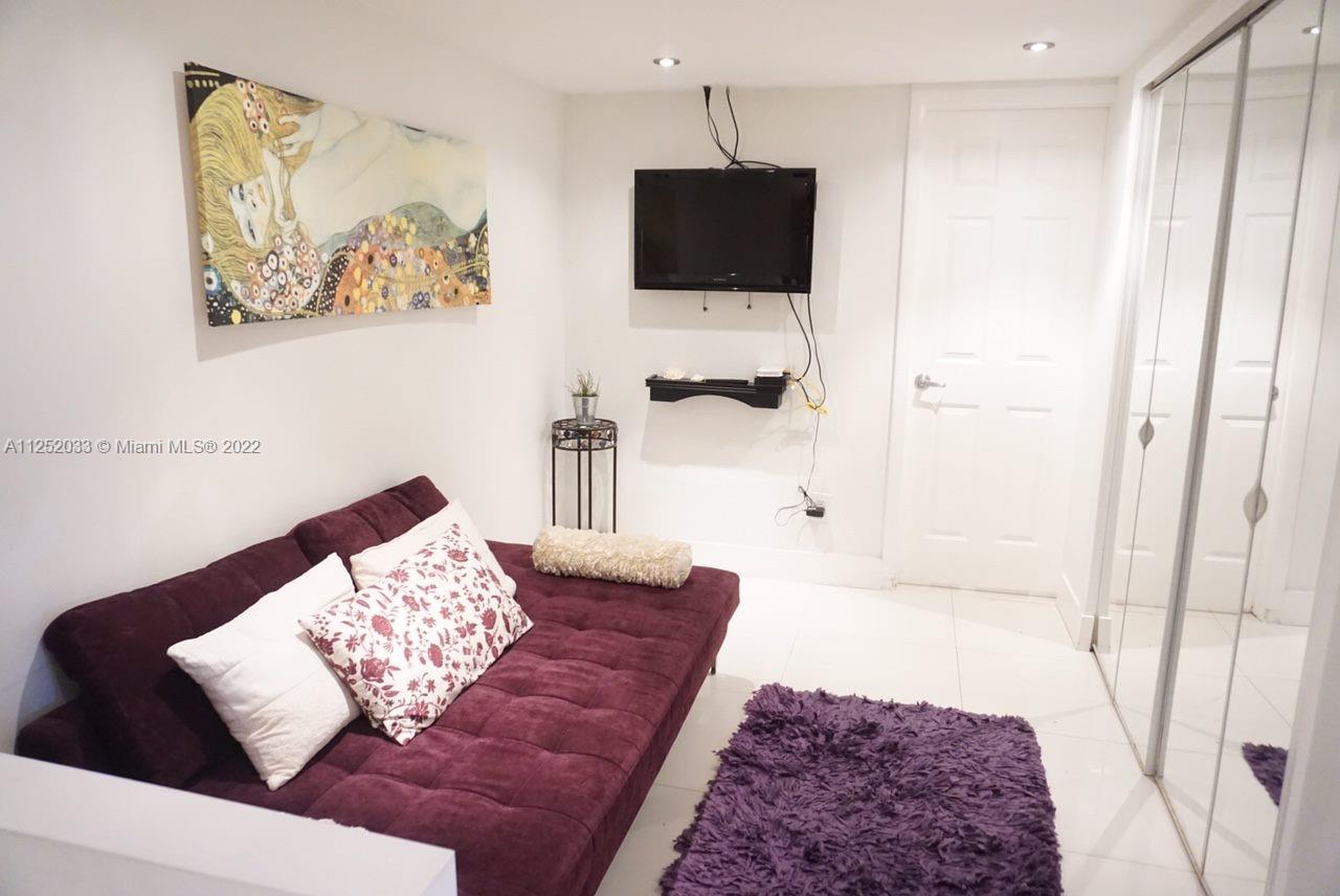 5161 Collins Avenue, Unit 309 Miami Beach, FL 33140 - Photo 2 of 29 a living room with furniture and a flat screen tv