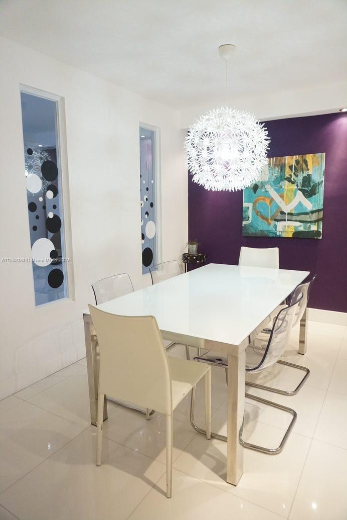 5161 Collins Avenue, Unit 309 Miami Beach, FL 33140 - Photo 5 of 29 a view of a dining room with furniture and chandelier
