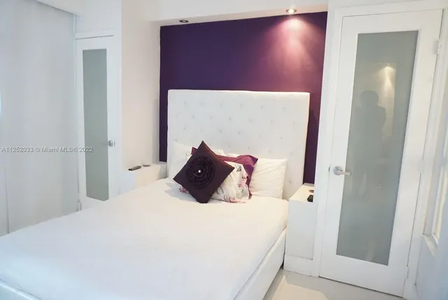 a bed sitting in a bedroom next to a bathroom