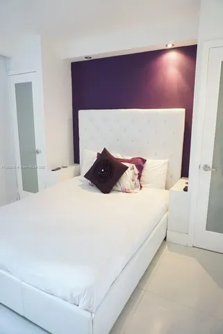 a bedroom with a bed and a potted plant