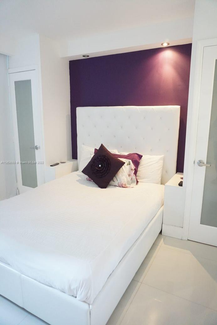 5161 Collins Avenue, Unit 309 Miami Beach, FL 33140 - Photo 8 of 29 a bedroom with a bed and a potted plant