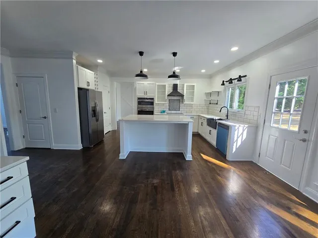 a kitchen with stainless steel appliances granite countertop a refrigerator a sink dishwasher and a stove