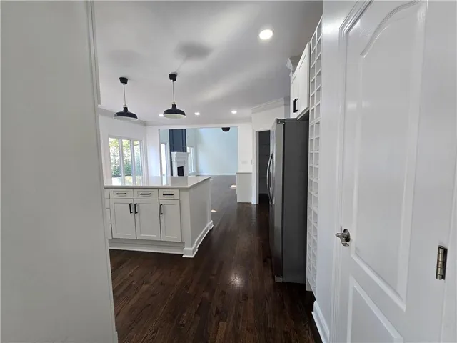an empty room with wooden floor fireplace and windows
