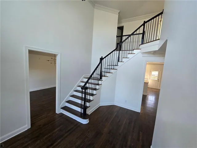 a large kitchen with a center island wooden floor and stainless steel appliances