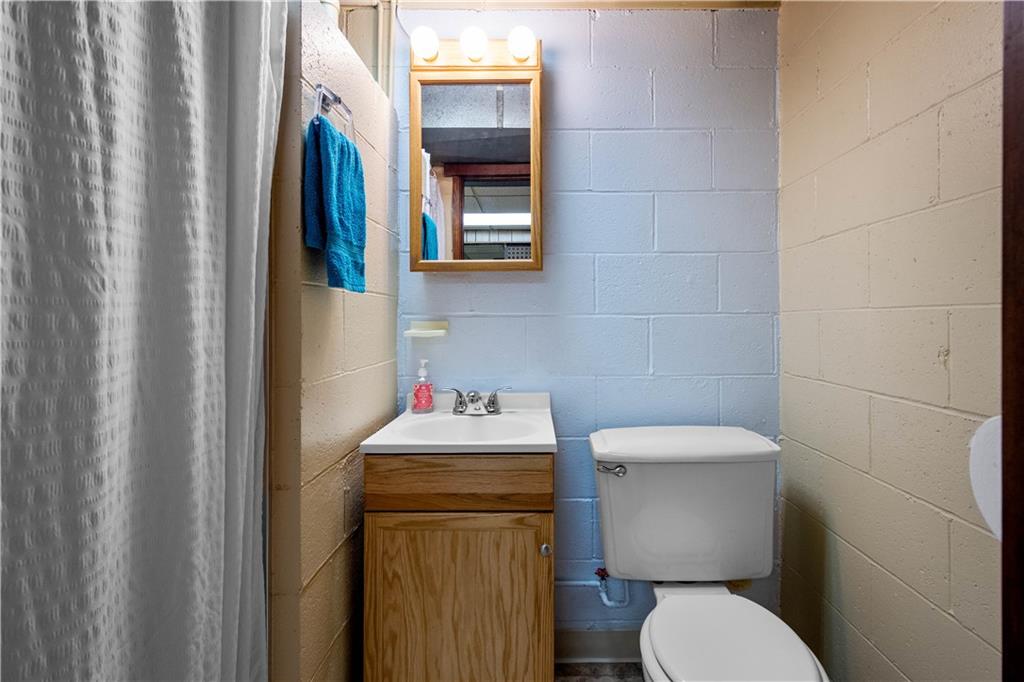 45 Harlem Avenue McKees Rocks, PA 15136 - Photo 22 of 31 a white toilet sitting next to a bathroom sink and vanity
