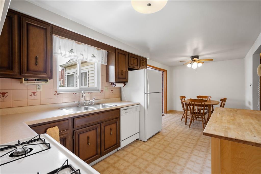 45 Harlem Avenue McKees Rocks, PA 15136 - Photo 9 of 31 a kitchen with a table chairs refrigerator and cabinets
