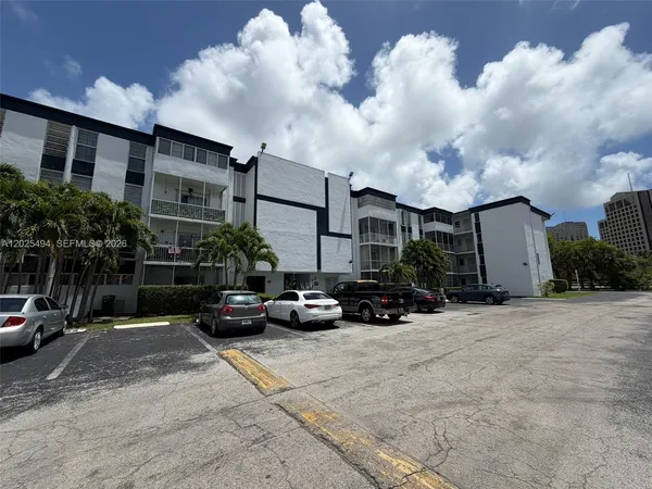 a view of a cars park in front of a building