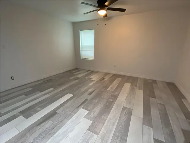 a view of a room with wooden floor and fan