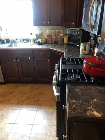 a kitchen with stainless steel appliances granite countertop a stove a sink and a microwave