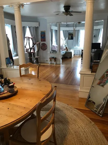 a dining room with furniture and wooden floor