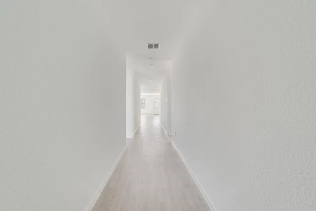 a view of a hallway with wooden floor