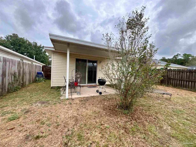a view of a house with backyard and wooden fence