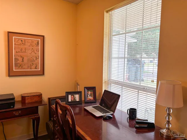 a view of a workspace with furniture and a window
